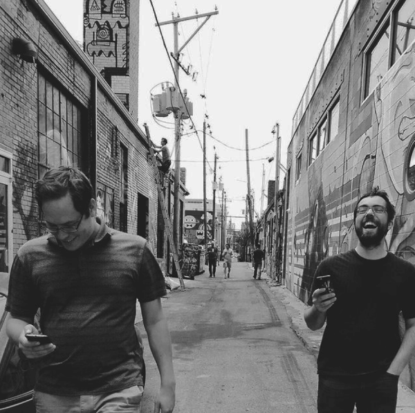 A black-and-white picture of By the Pixel employees playing a game in an alley.