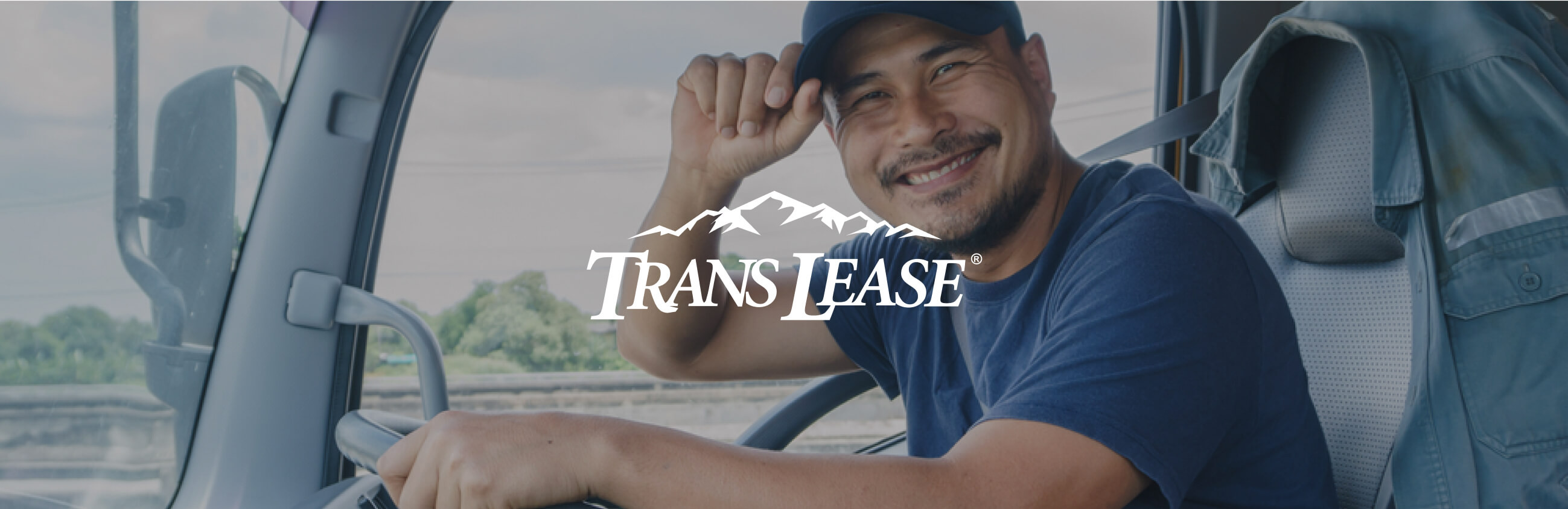 Smiling man driving a truck with Trans Lease logo